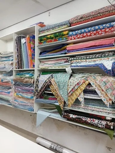 Estante da loja com tecidos estampados dobrados em diversas cores